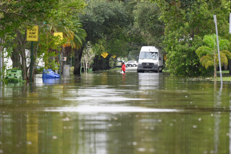 A woman walking through floodwaters.