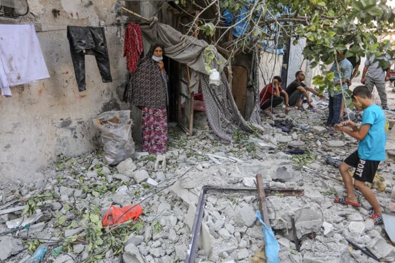 Palestinians inspect the destruction caused by an Israeli air strike that killed at least ten people and injured others. Abed Rahim Khatib/dpa