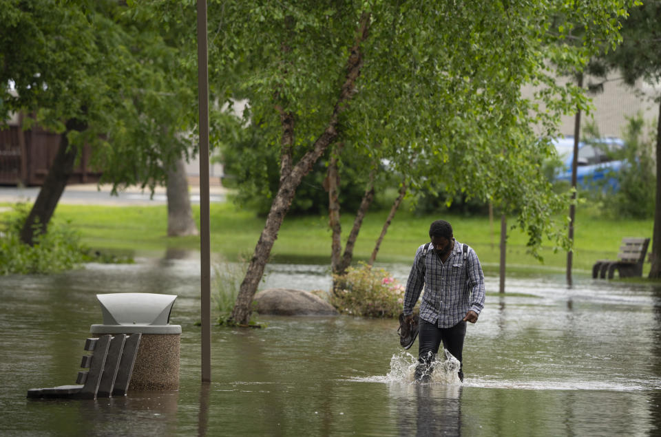 A man wades through a flooded park in Minnesota.