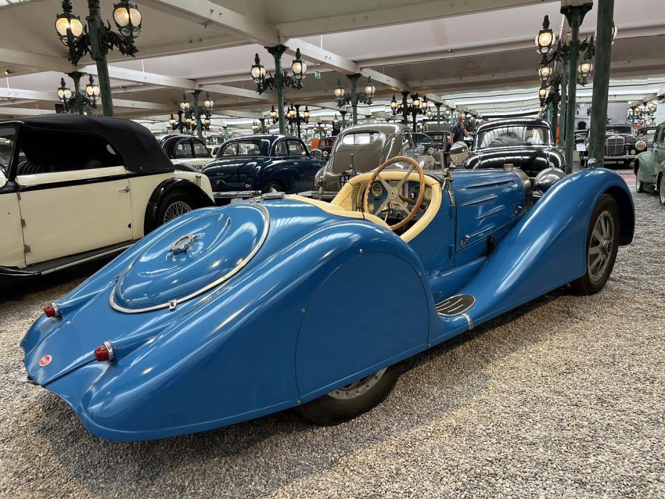 a blue sports car in a showroom with other cars