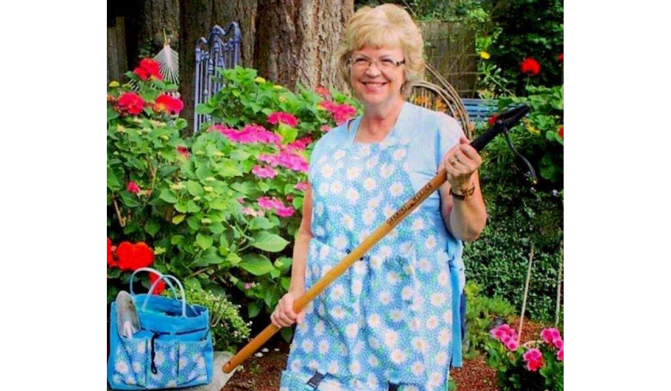 Older woman in a garden with a Grampa's Weeder.