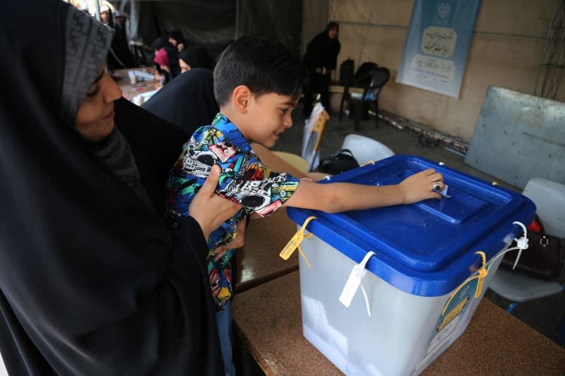 An Iranian child casts his mother's ballot during Iran's 2024 early Presidential elections at Shah Abdol-Azim Shrine polling station in Shahre Ray, southern Tehran. Following the helicopter crash that claimed the life of conservative president Ebrahim Raisi, Iranians vote on June 28 to choose a new president. Around 61 million Iranians are eligible to participate in the election. Rouzbeh Fouladi/ZUMA Press Wire/dpa