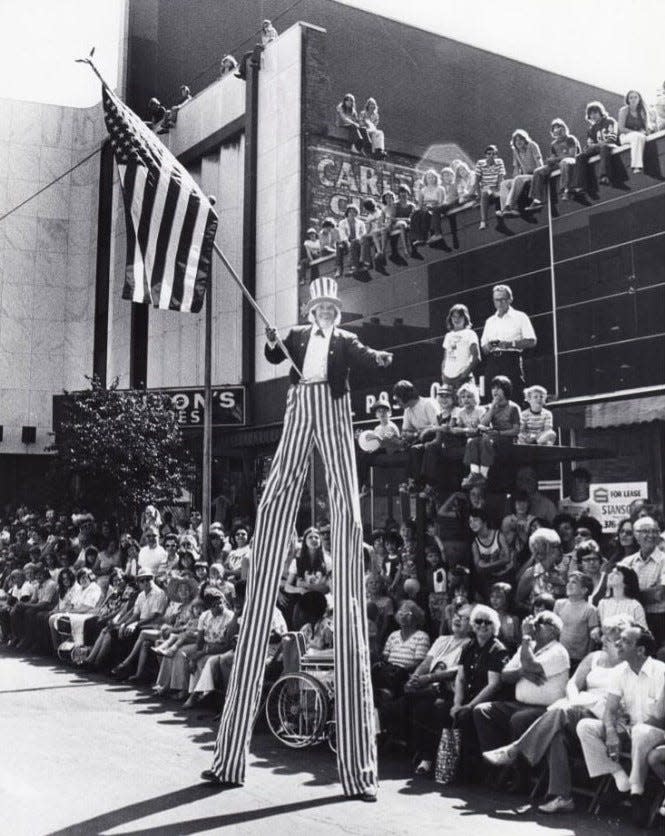 Stilt walker Geza Geier waves the American flag as Uncle Sam during the bicentennial parade July 4, 1976, in downtown Akron.