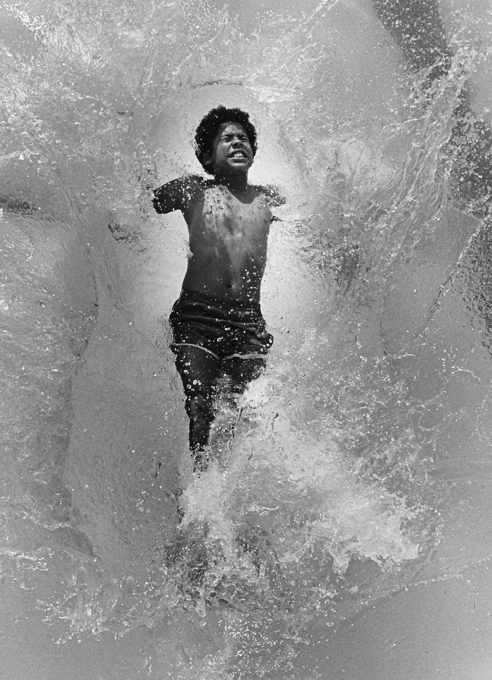 Freddie Walker, 13, falls into the swimming pool at Reservoir Park in Goodyear Heights on July 14, 1980, in Akron.