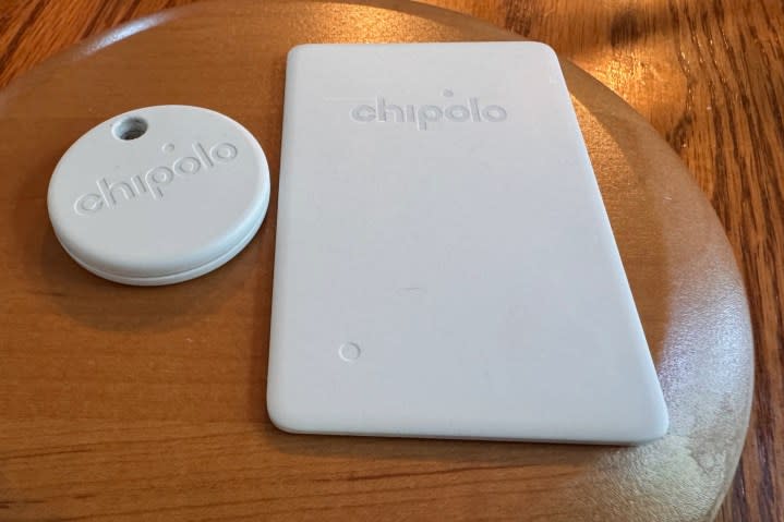 A Chipolo ONE Point and Chipolo CARD Point sitting on a wood table.