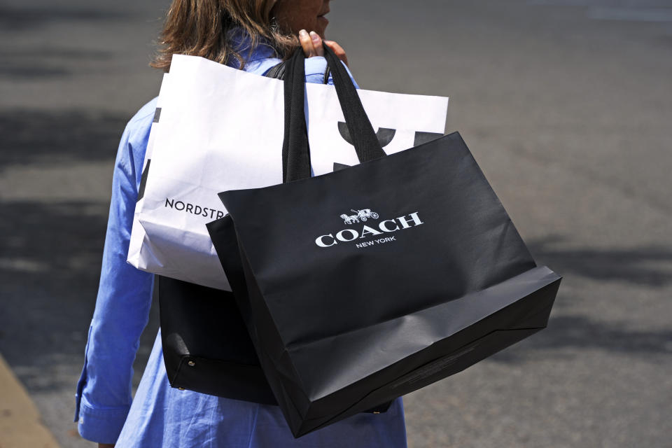 A shopper carries bags in Pittsburgh on Monday, June 3, 2024. On Friday, June 14, 2024, the University of Michigan releases its preliminary reading of consumer sentiment for June. (AP Photo/Gene J. Puskar)