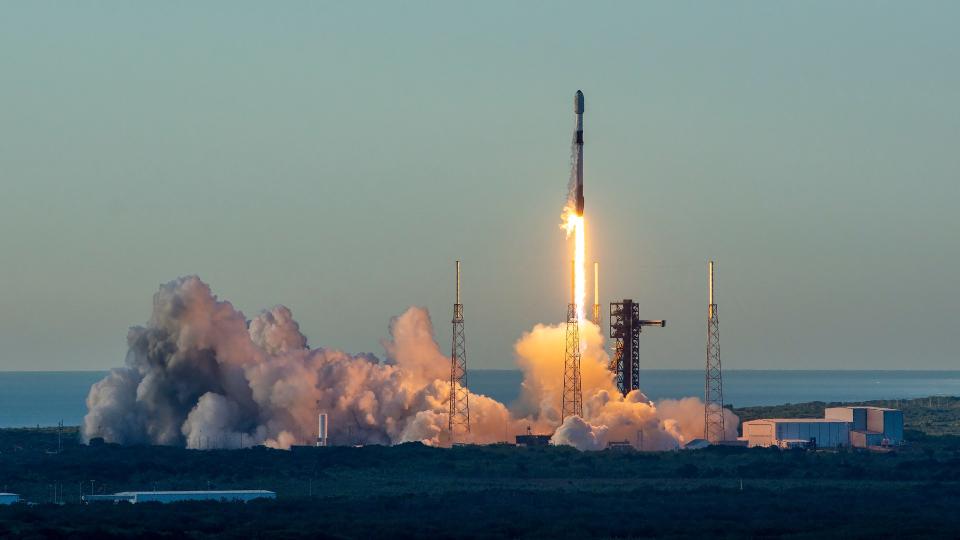 a rocket launches above a cloud of smoke and fire