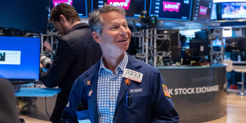 A smiling trader on the floor of the New York Stock Exchange.