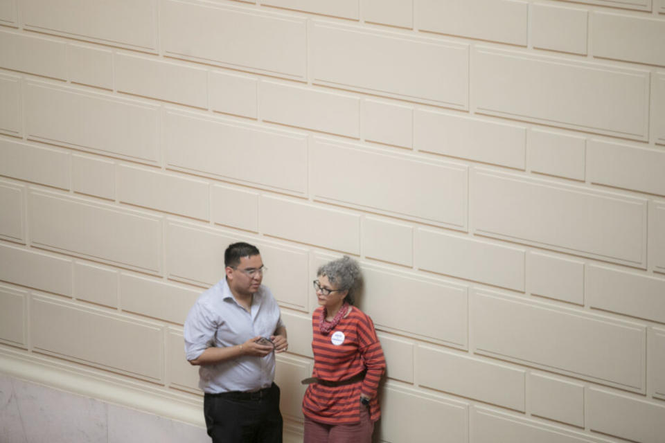  Democratic Reps. Enrique Sanchez and Jennifer Stewart chat on the House floor on May 28, 2024. (Alexander Castro/Rhode Island Current)