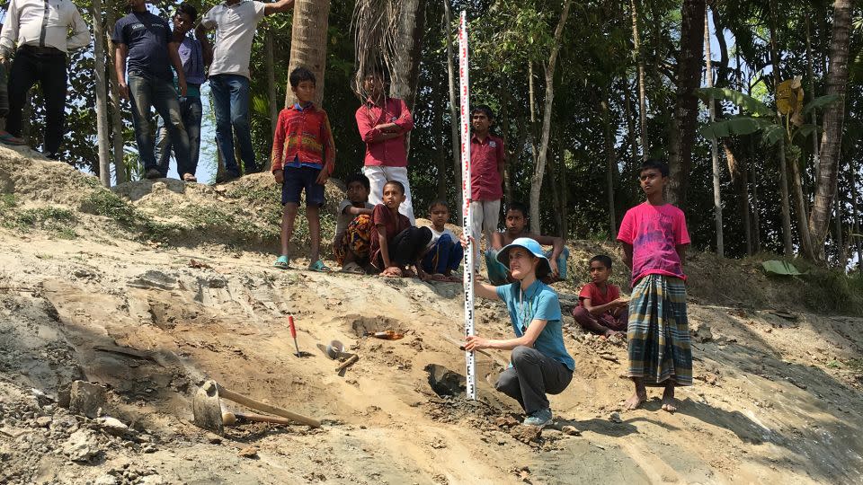 Rachel Bain, a report coauthor and a researcher at Vanderbilt University in Nashville when conducting the study, surveys the elevation and orientation of sand dikes in the Ganges floodplain of Bangladesh. - Liz Chamberlain