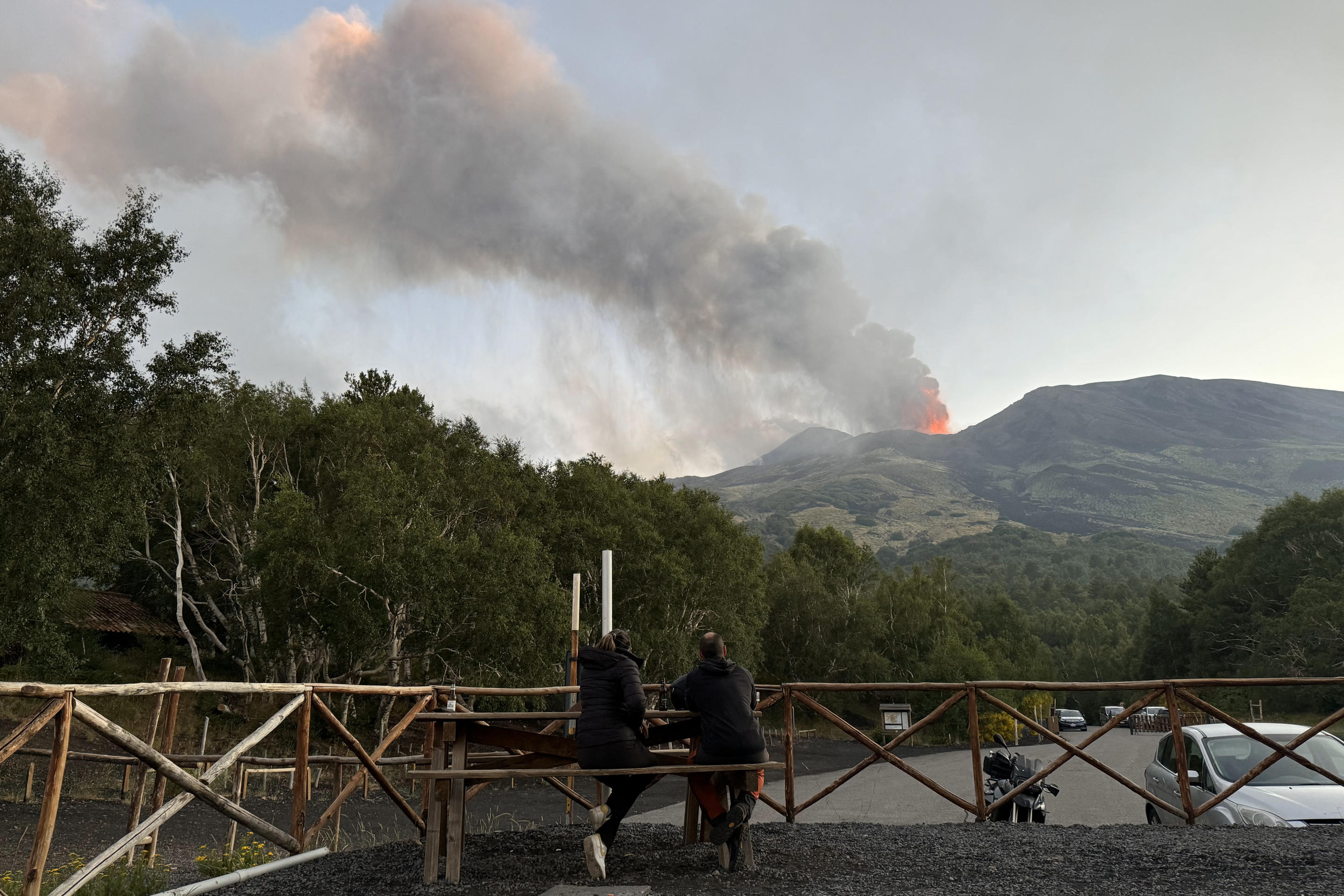 People watch an eruption of a volcano.