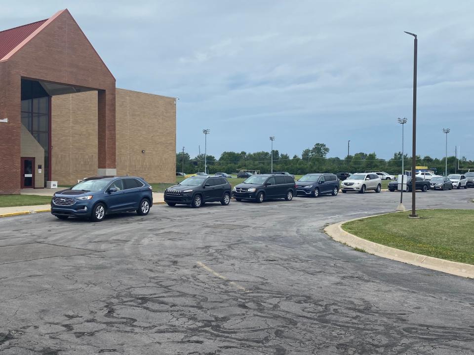 Cars line up out the parking lot for their weekly meal packs.