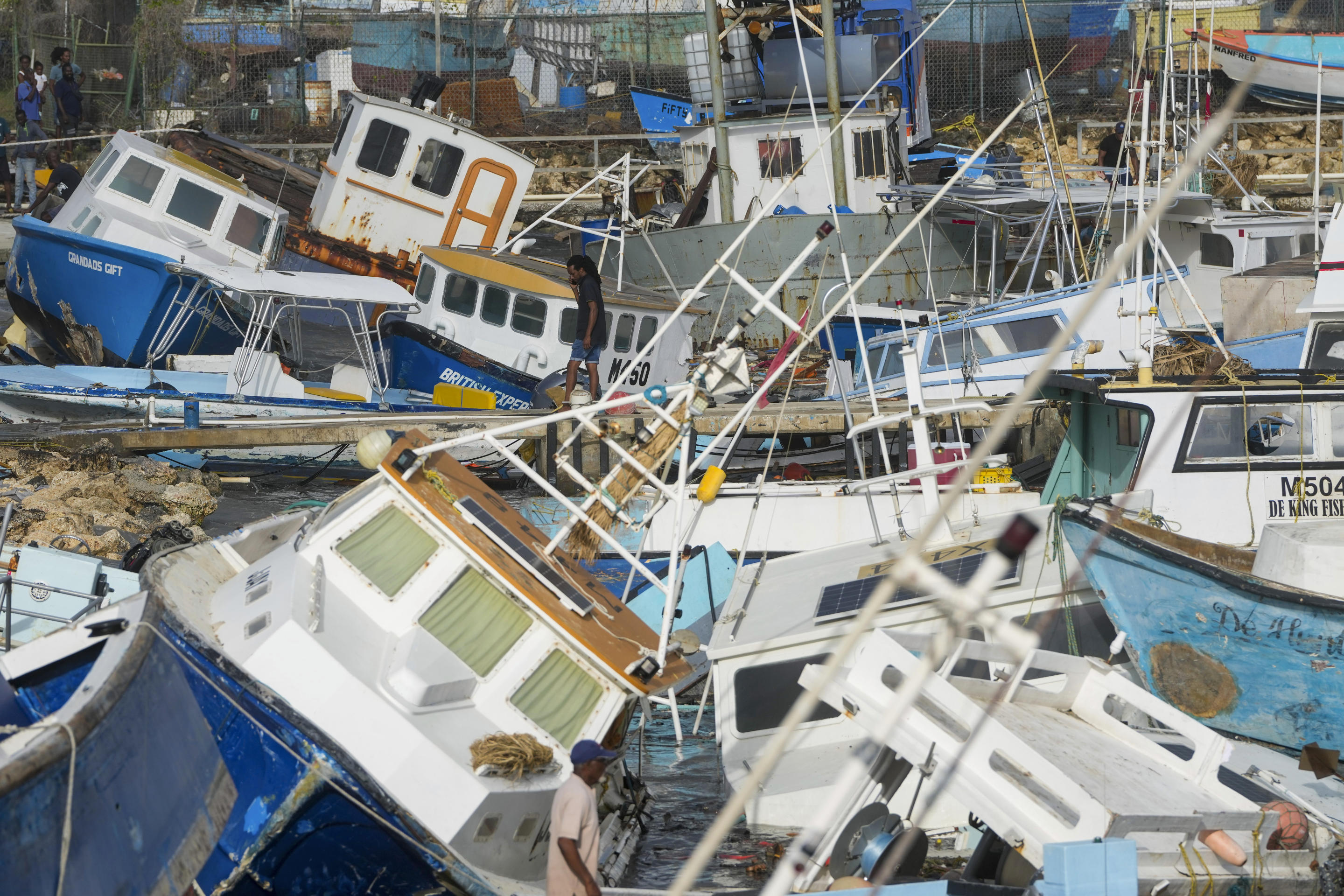 A fisherman looks at fishing vessels damaged by Hurricane Beryl at the Bridgetown Fisheries in Barbados.