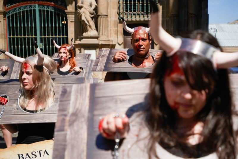 Protesters with their faces stained with fake blood and chains on their wrists, take part in a demonstration against bullfights, ahead of the San Fermin 2024 festivities. The famous running of the bulls event in Pamplona, northern Spain, kicked off on Saturday, despite protests from animal rights activists. Elsa A Bravo/SOPA Images via ZUMA Press Wire/dpa