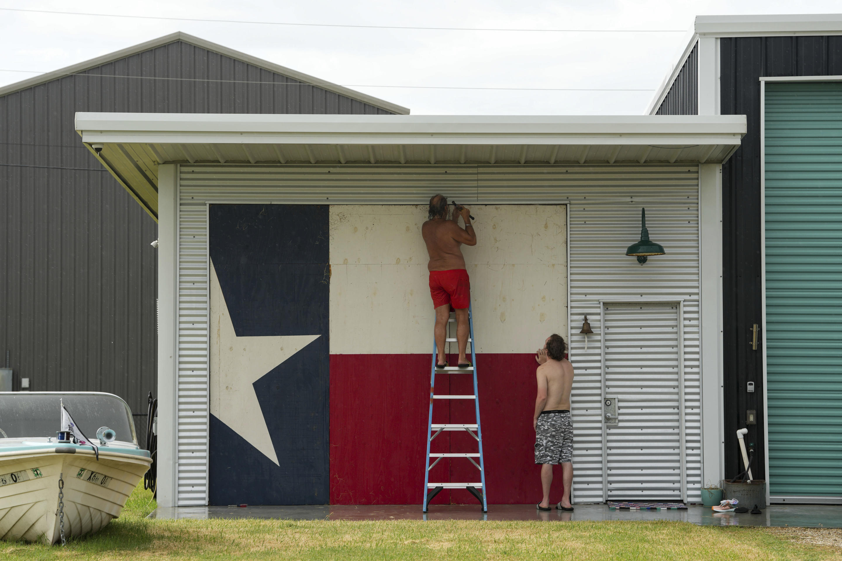 Clyde George, on a ladder at left, and his son Chris George board up their home ahead of the arrival of Tropical Storm Beryl on July 7, in Port O'Connor, Texas.