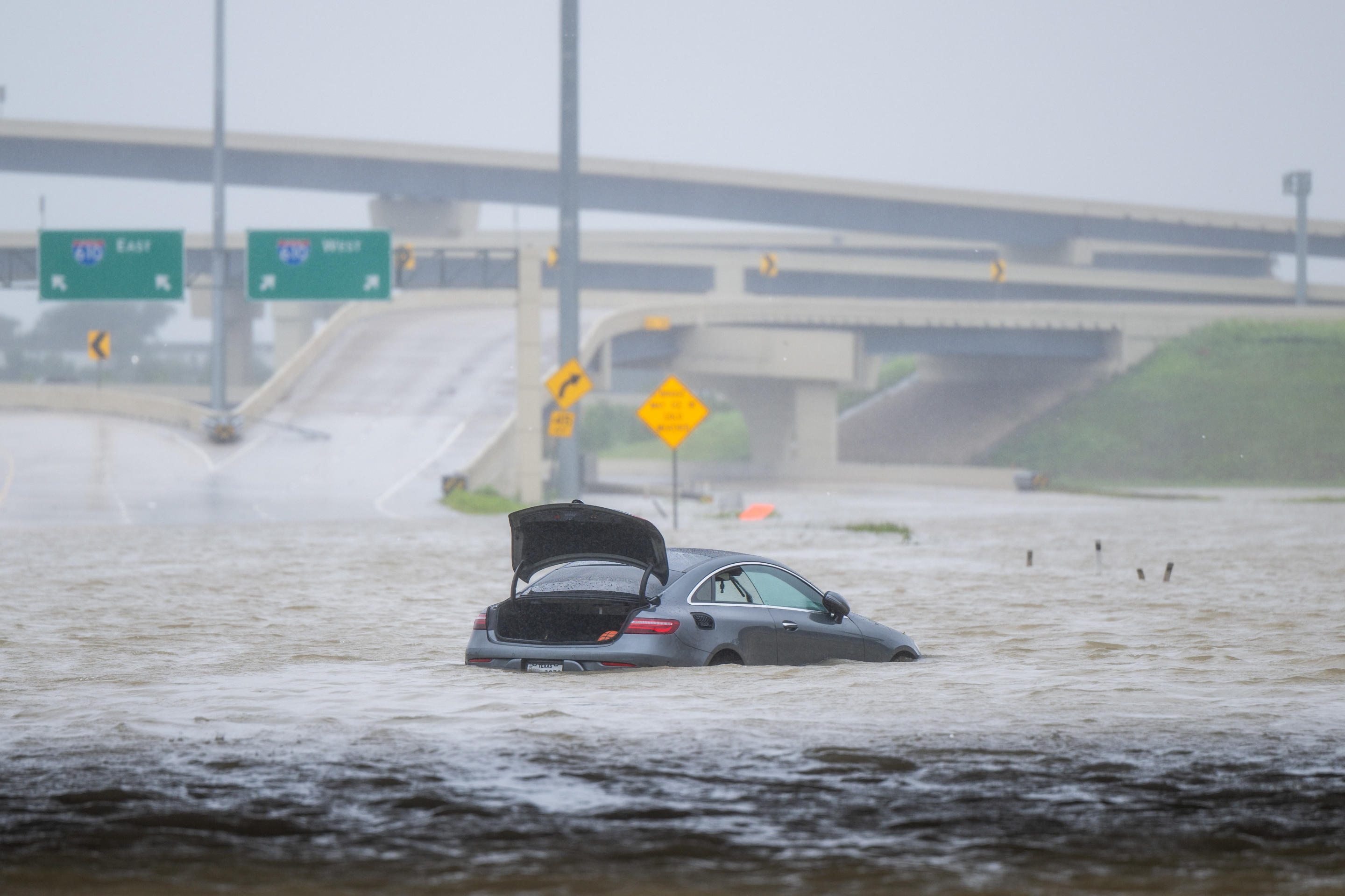 A vehicle is left abandoned in floodwaters on a highway after Hurricane Beryl swept through the area on Monday in Houston. 