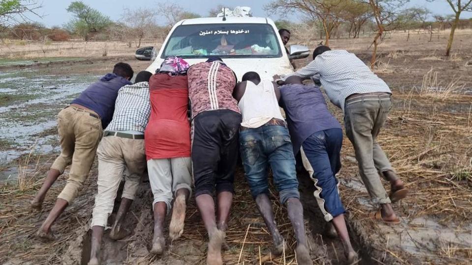 People pushing a car