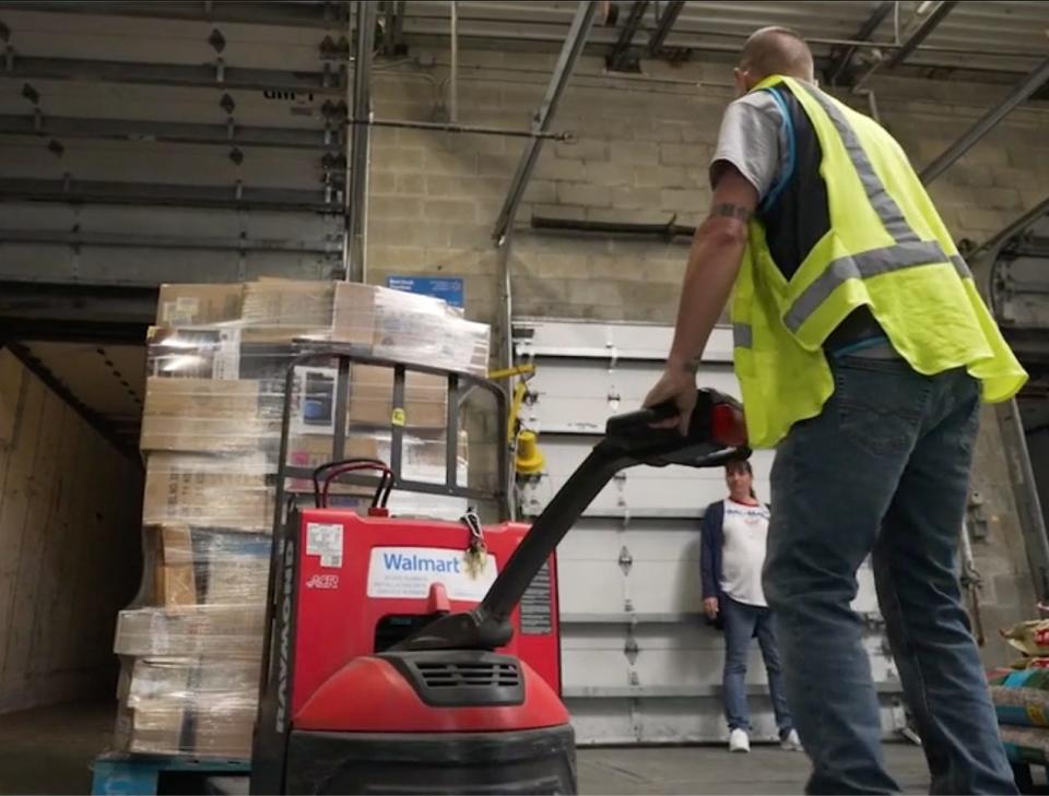 A Walmart worker moving a pallet