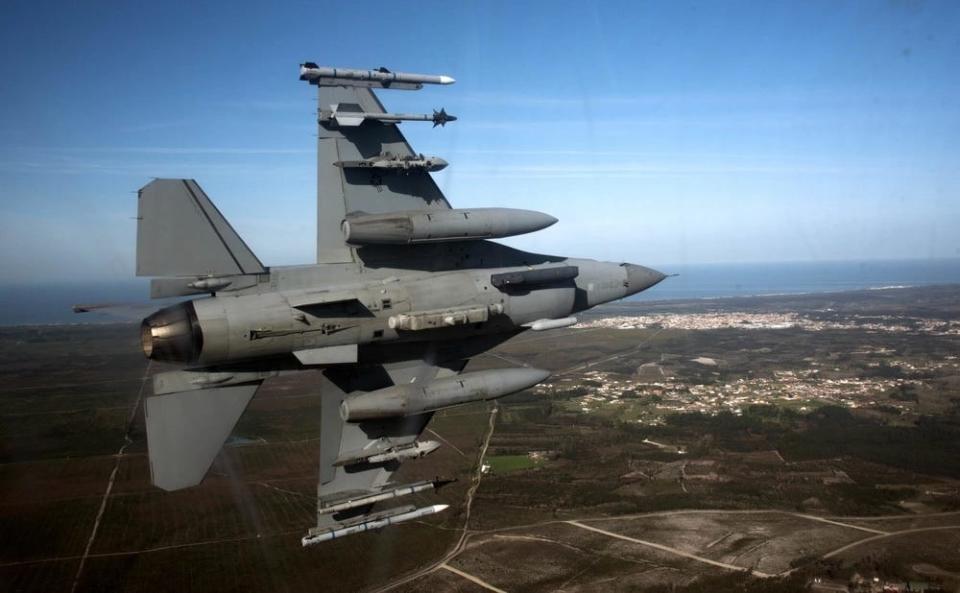 a gray fighter aircraft turned on its side while flying