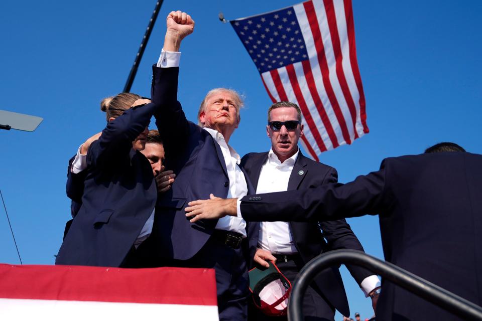 Republican presidential candidate former President Donald Trump gestures as he is surrounded by U.S. Secret Service agents as he leaves the stage at a campaign rally, Saturday, July 13, 2024, in Butler, Pa. (AP Photo/Evan Vucci)