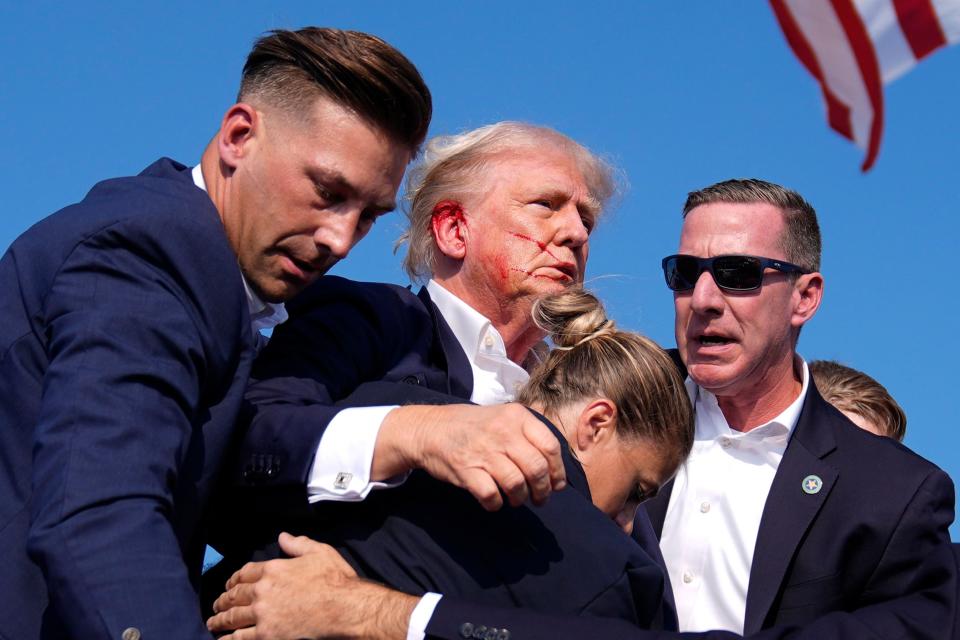 Republican presidential candidate former President Donald Trump gestures as he is surrounded by U.S. Secret Service agents at a campaign rally, Saturday, July 13, 2024, in Butler, Pa. (AP Photo/Evan Vucci)