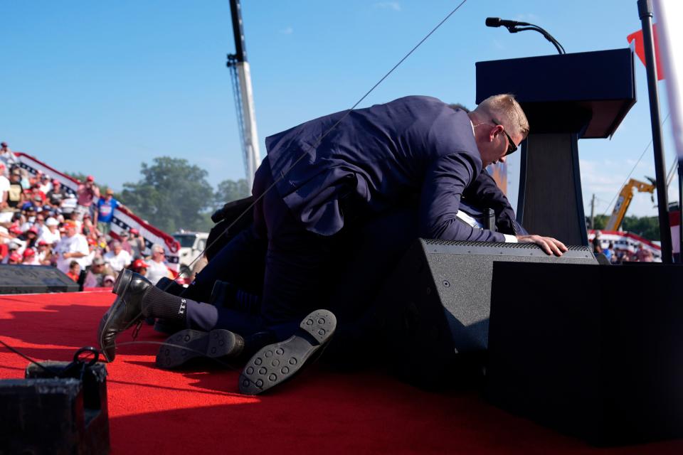 Republican presidential candidate former President Donald Trump is covered by U.S. Secret Service agents at a campaign rally, Saturday, July 13, 2024, in Butler, Pa. (AP Photo/Evan Vucci)