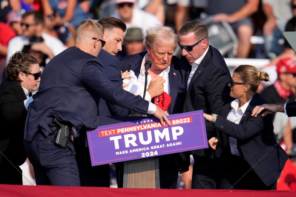 Republican presidential candidate former President Donald Trump is helped off the stage at a campaign event in Butler, Pa., Saturday, July 13, 2024. (AP Photo/Gene J. Puskar)