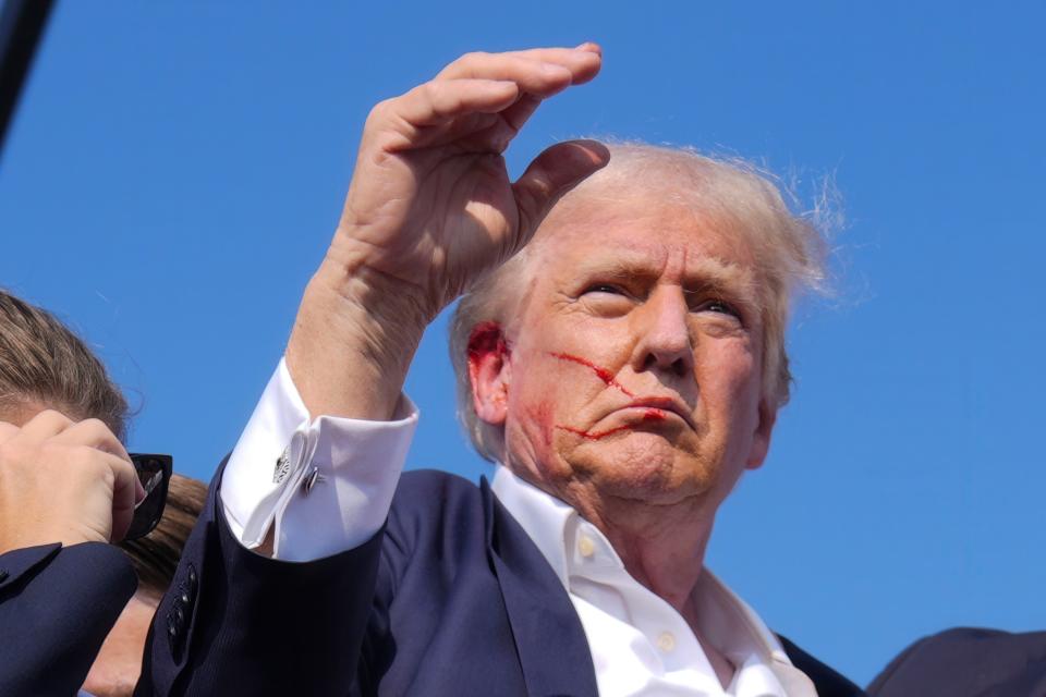 Republican presidential candidate former President Donald Trump waves from the stage as he is surrounded by U.S. Secret Service agents at a campaign rally, Saturday, July 13, 2024, in Butler, Pa. (AP Photo/Evan Vucci)