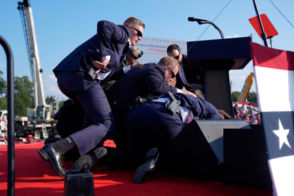 Republican presidential candidate former President Donald Trump is covered by U.S. Secret Service agents at a campaign rally, Saturday, July 13, 2024, in Butler, Pa. (AP Photo/Evan Vucci)