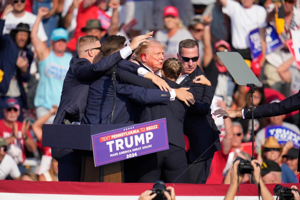 Republican presidential candidate former President Donald Trump is helped off the stage at a campaign event in Butler, Pa., on Saturday, July 13, 2024. (AP Photo/Gene J. Puskar)