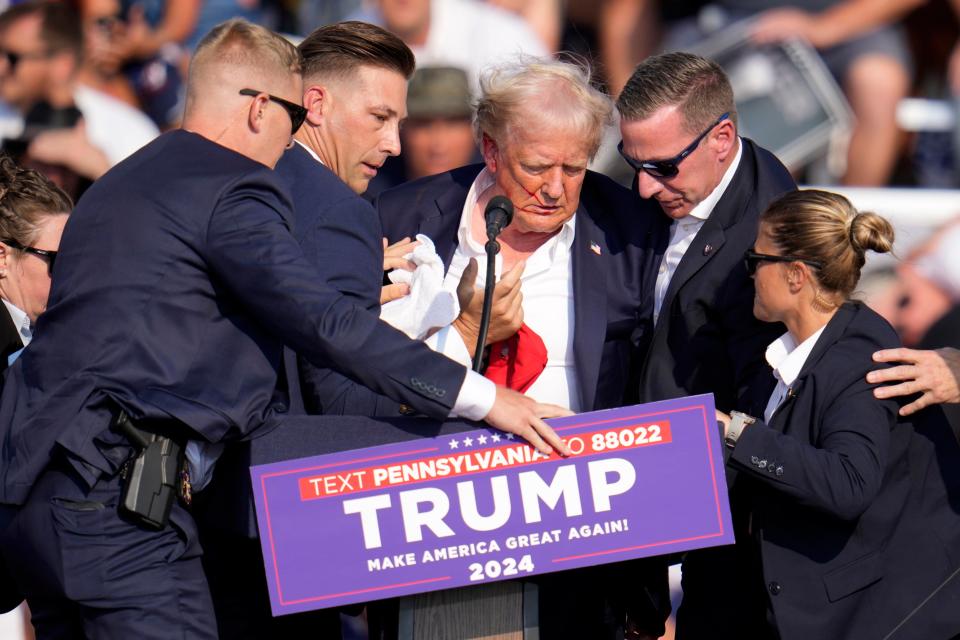 Republican presidential candidate former President Donald Trump is helped off the stage at a campaign event in Butler, Pa., on Saturday, July 13, 2024. (AP Photo/Gene J. Puskar)