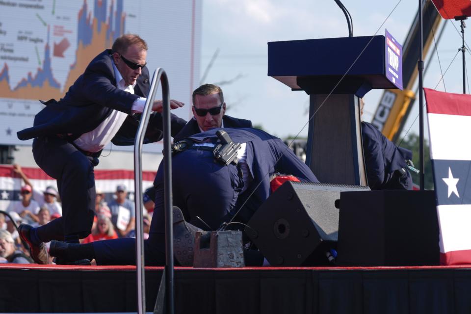 Republican presidential candidate former President Donald Trump is covered by U.S. Secret Service agents on stage at a campaign rally, Saturday, July 13, 2024, in Butler, Pa. (AP Photo/Evan Vucci)