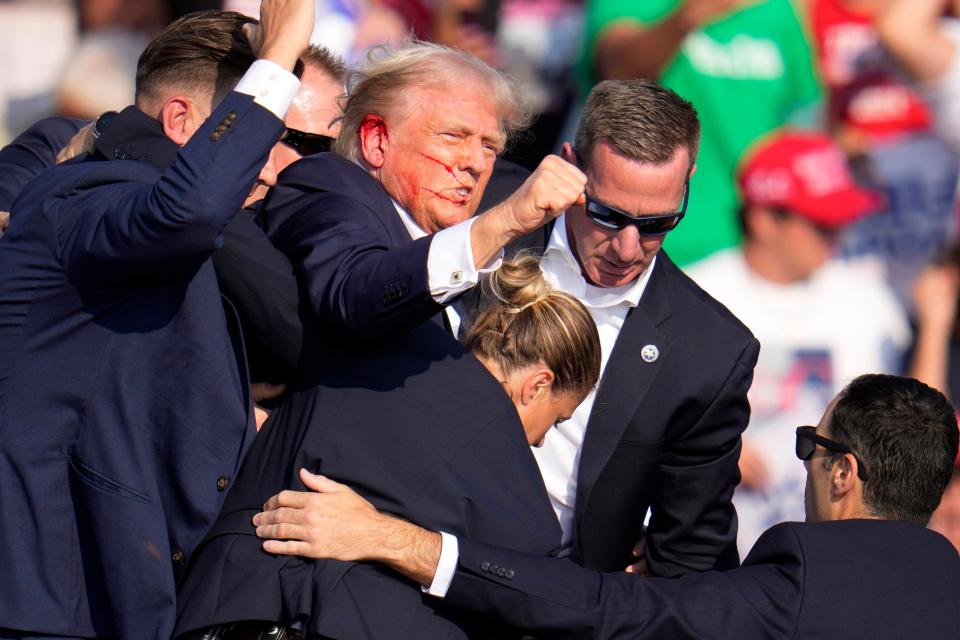 Republican presidential candidate former President Donald Trump is helped off the stage by U.S. Secret Service at a campaign event in Butler, Pa., on Saturday, July 13, 2024. (AP Photo/Gene J. Puskar)