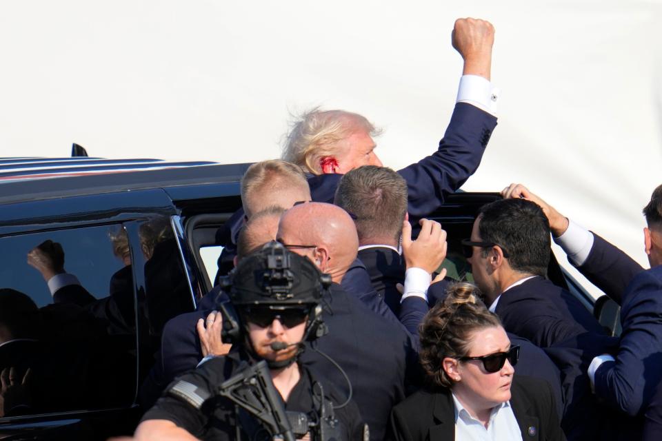 Republican presidential candidate former President Donald Trump pumps his fist as he is helped into a vehicle at a campaign event in Butler, Pa., on Saturday, July 13, 2024. (AP Photo/Gene J. Puskar)