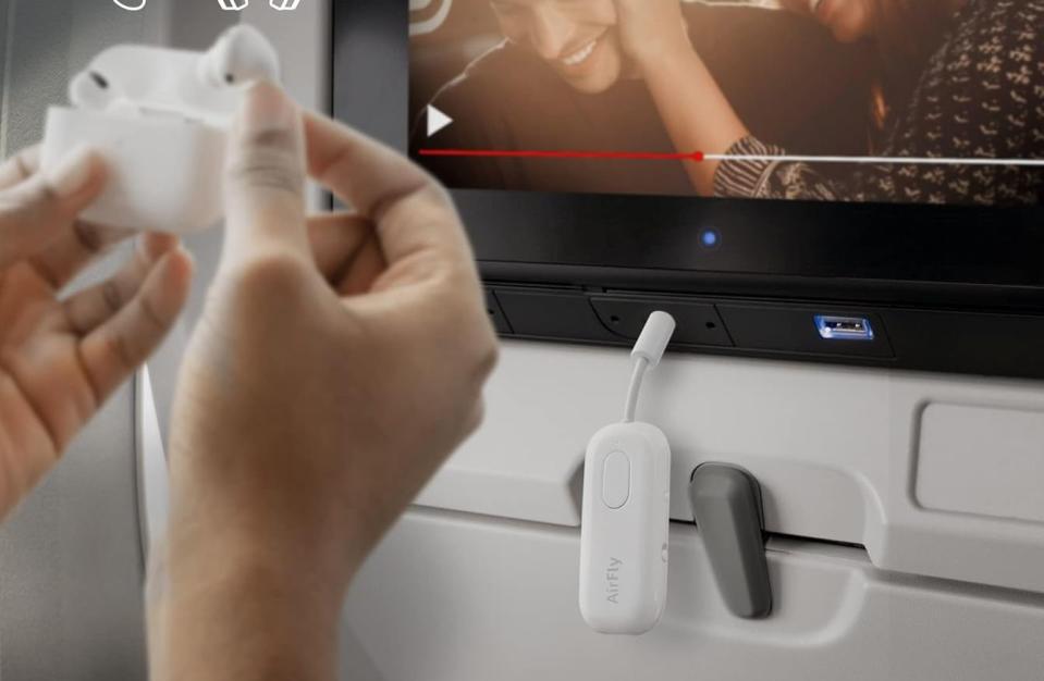 A photo showing the AirFly Pro plugged into an airplane's headphone jack.