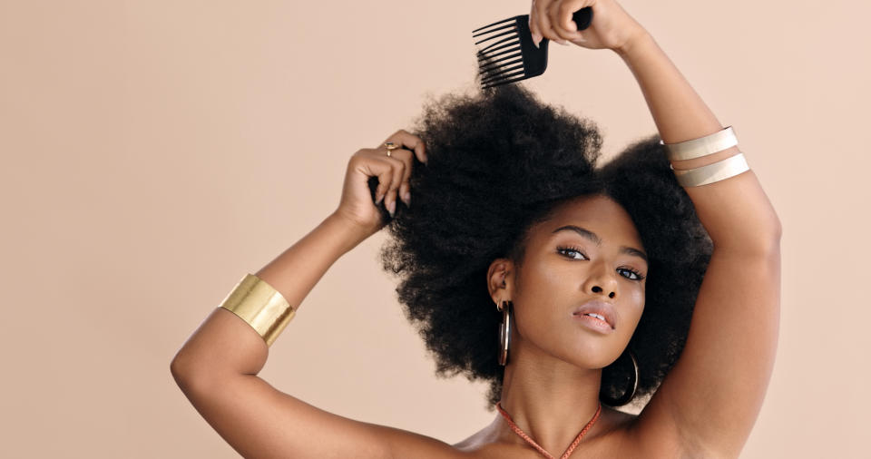 A woman combs her hair.