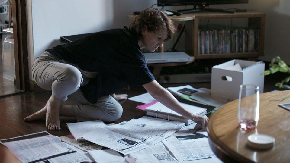 South African journalist Isa Jacobson sitting on the floor crouched over files relating to Louis van Schoor's case