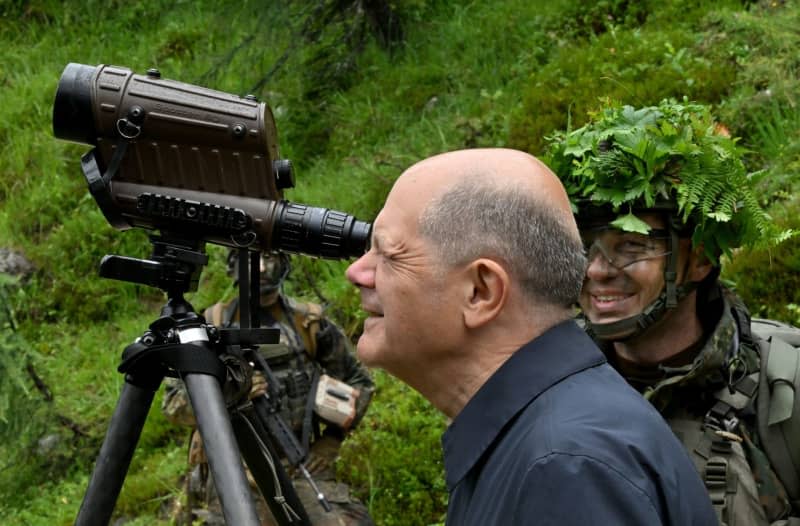 German Chancellor Olaf Scholz (L) is shown various combat exercises during his visit to the mountain infantry brigade on the Reiteralpe. Peter Kneffel/dpa