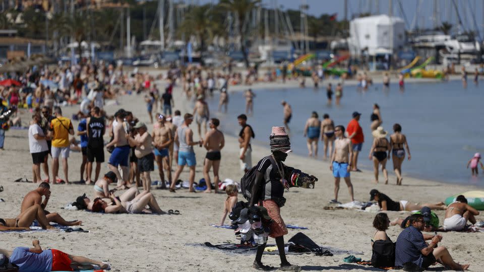 Tourists sunbathe in El Arenal beach in Palma de Mallorca, Spain. - Juan Medina/Reuters