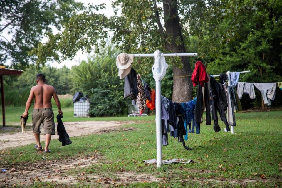 The U.S. Occupational Health and Safety Administration is proposing a federal rule to protect workers from heat illness. Here, a farmworker is shown carrying dried clothes from a clothesline at a Johnston County farmworker camp in August 2020.