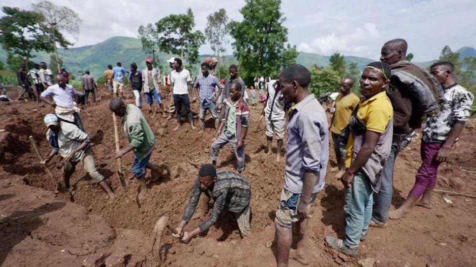 Group of people digging in the mud