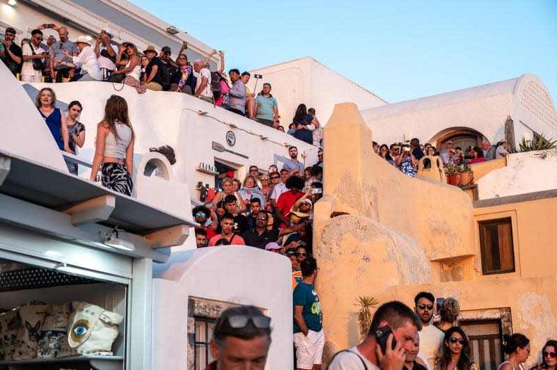 Travellers gathering to watch the sunset at Oia on the island of Santorini, 30 June 2024. With the number of visitors to the island of Santorini increasing unchecked, the authorities are beginning to think about imposing certain limits on the number of travellers. - Photo: XAVIER DUVOT/Hans Lucas/AFP (Getty Images)