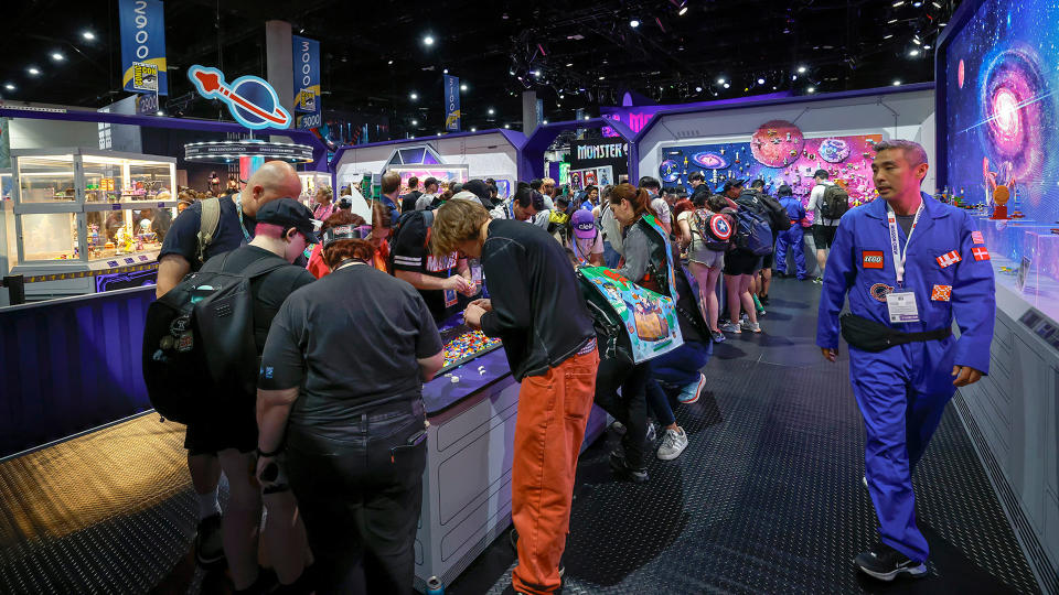 a large group of people congregate on a show floor at a comics convention