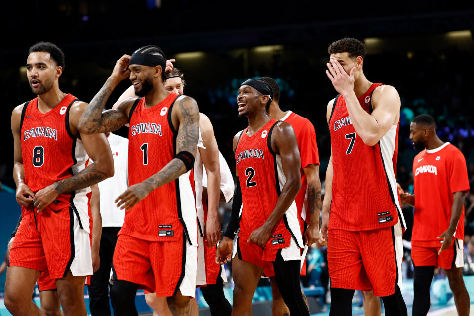 (From L) Canada's #08 Trey Lyles, Canada's #01 Nickeil Alexander-Walker, Canada's #02 Shai Gilgeous-Alexander and Canada's #07 Dwight Powell celebrate at the end of the men's preliminary round group A basketball match between Greece and Canada during the Paris 2024 Olympic Games at the Pierre-Mauroy stadium in Villeneuve-d'Ascq, northern France, on July 27, 2024. (Photo by Sameer Al-Doumy / AFP) (Photo by SAMEER AL-DOUMY/AFP via Getty Images)