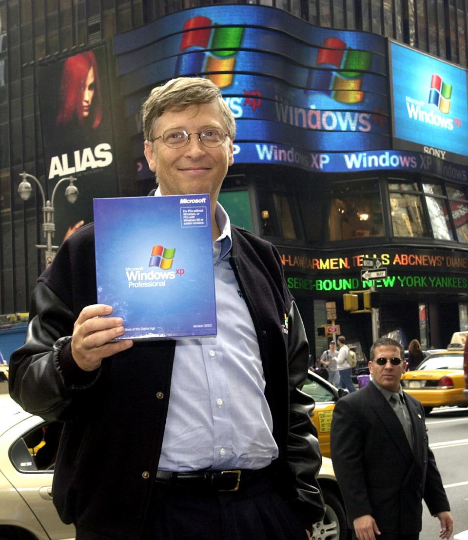 (FILES) This file photo shows Microsoft Chairman Bill Gates holding up a copy of the new Windows XP operating system while posing for photos in New York's Times Square during the  Windows XP launch 25 October, 2001 in New York. Microsoft and the US Justice Department have agreed on the framework for a settlement in the government's marathon antitrust case against the software giant, with a Federal judge ordering the negotiations to be concluded by 02 November, 2001.   AFP PHOTO   Henny Ray ABRAMS (Photo by HENNY RAY ABRAMS / AFP) (Photo by HENNY RAY ABRAMS/AFP via Getty Images)