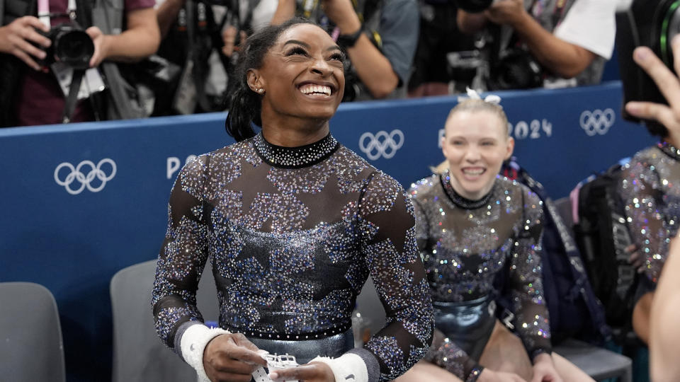 Biles shows off a big smile after competing on the uneven bars at the Summer Games. 