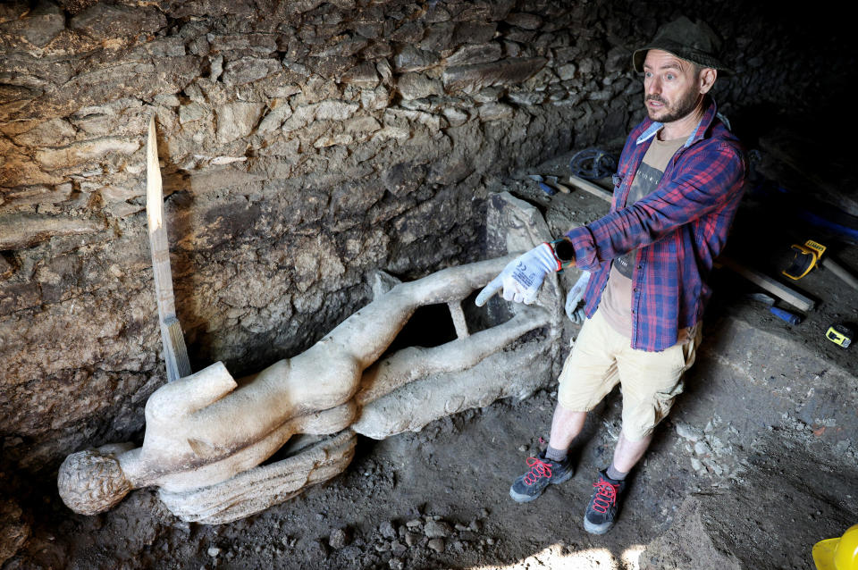 An archaeologist stands next to a marble statue, uncovered at the site of the remains of the ancient city of Heraclea Sintica, near the village of Rupite, Bulgaria, July 5, 2024. / Credit: Spasiyana Sergieva/REUTERS