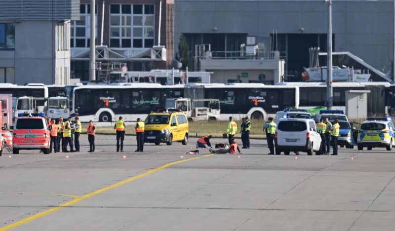 Emergency vehicles from the police, fire department and airport security are parked on the apron of Frankfurt Airport, where two activists have taped themselves up. Several demonstrators had forced their way onto the airport grounds early in the morning and stuck themselves there. As a result, air traffic was temporarily suspended. It has since been partially resumed. Arne Dedert/dpa