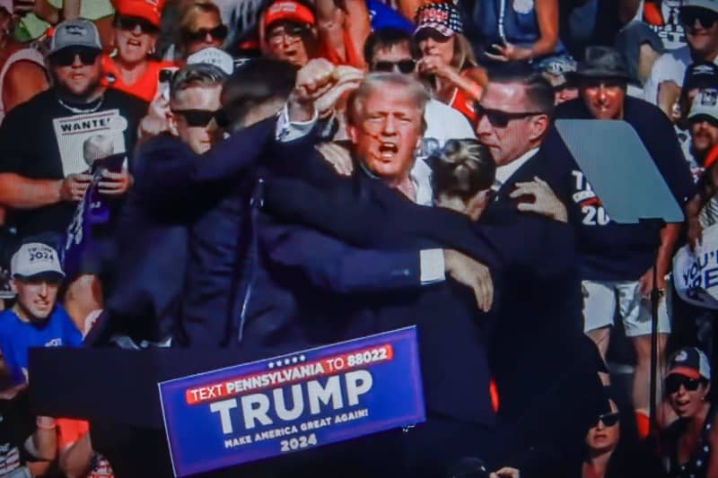 Former US President Donald Trump is rushed off stage by secret service after being struck by gunfire during his Presidential Election campaign rally in Butler Pennsylvania. Artem Priakhin/SOPA Images via ZUMA Press Wire/dpa