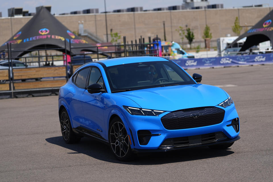 A motorist puts an electric 2024 Ford Mustang Mach-E through its paces on a test track at the Electrify Expo in The Yards Sunday, July 14, 2024, in north Denver. Ford reports earnings on Wednesday, July 24, 2024. (AP Photo/David Zalubowski)